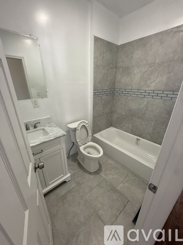 A bathroom with a toilet, sink, and bathtub.