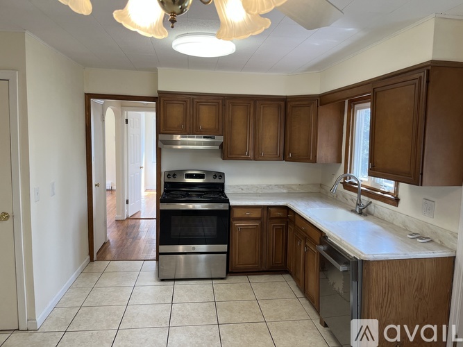 A kitchen with wooden cabinets and a stainless steel oven.