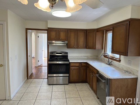 A kitchen with wooden cabinets and a stainless steel oven.