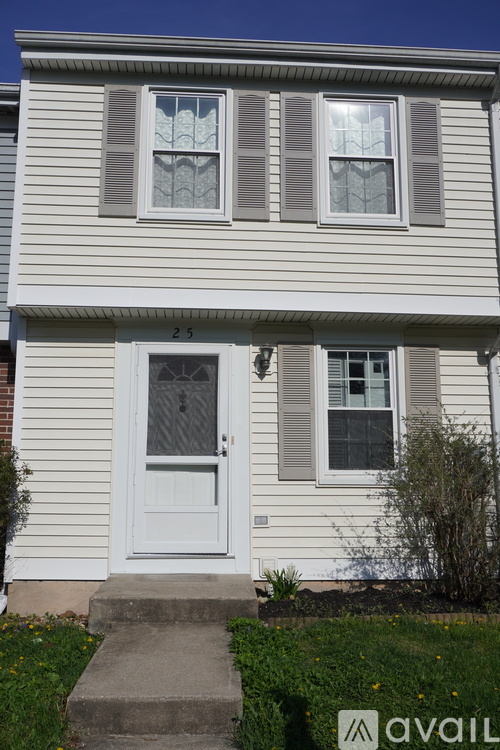 A house with a white door and two windows with shutters.