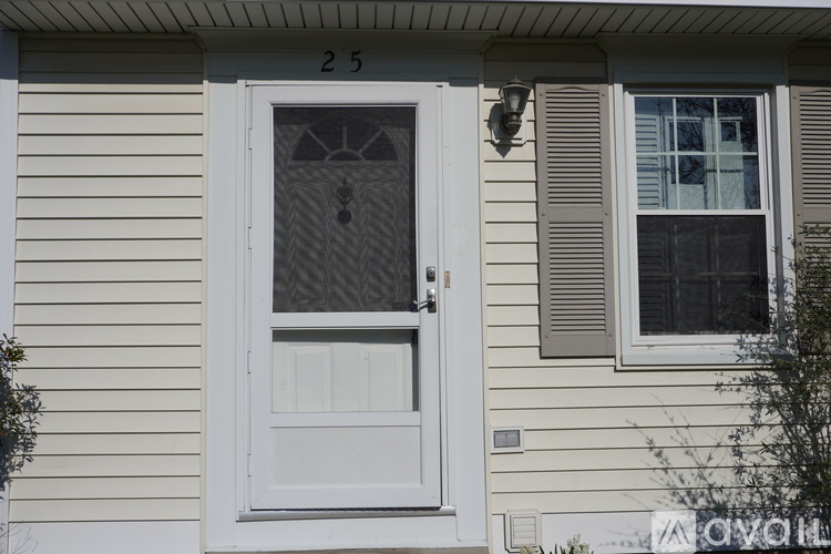 A white door with a glass window is on the front of a house.