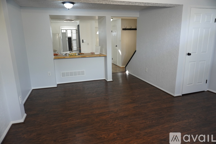 A spacious room with wood flooring and a mirrored vanity.