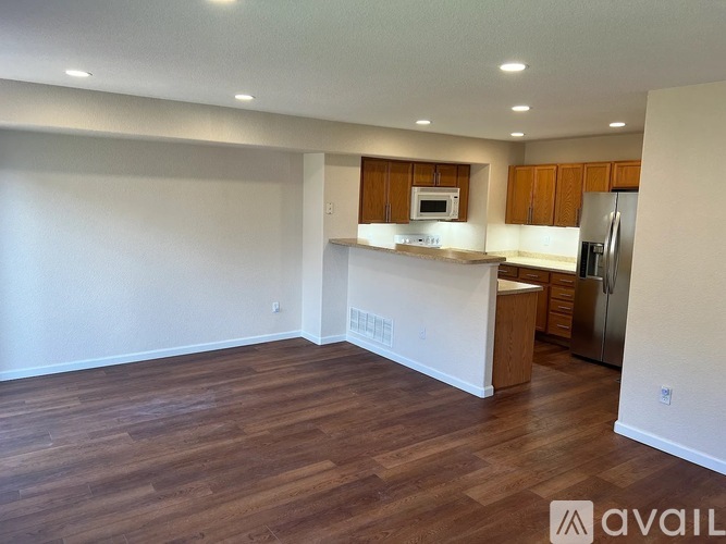 A kitchen with wooden floors and white walls.
