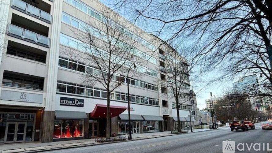 A street view of a building with a red awning and a sign that says "AVAIL".