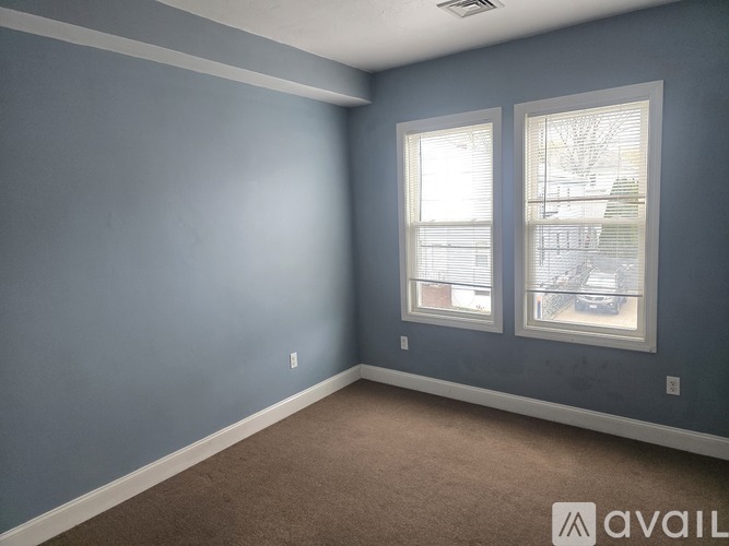 A room with two windows and a carpeted floor.
