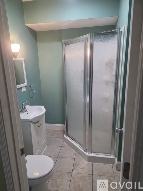A bathroom with a toilet, sink, and shower.
