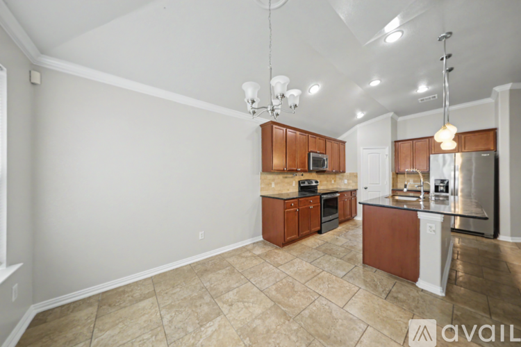 A kitchen with brown cabinets and a tiled floor.