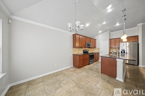 A kitchen with brown cabinets and a tiled floor.