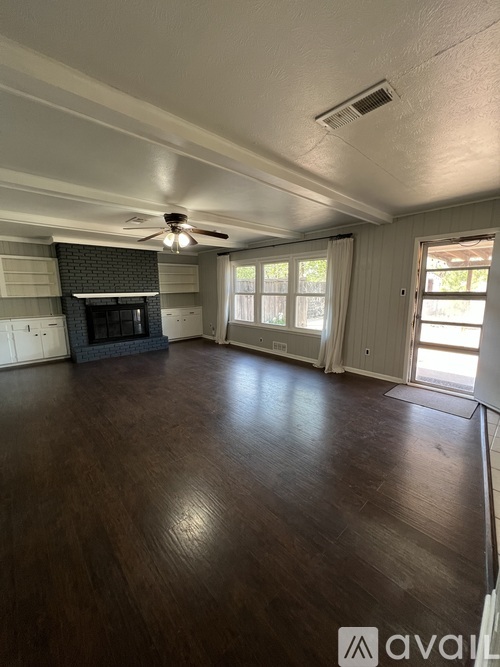 A living room with a fireplace and a ceiling fan.