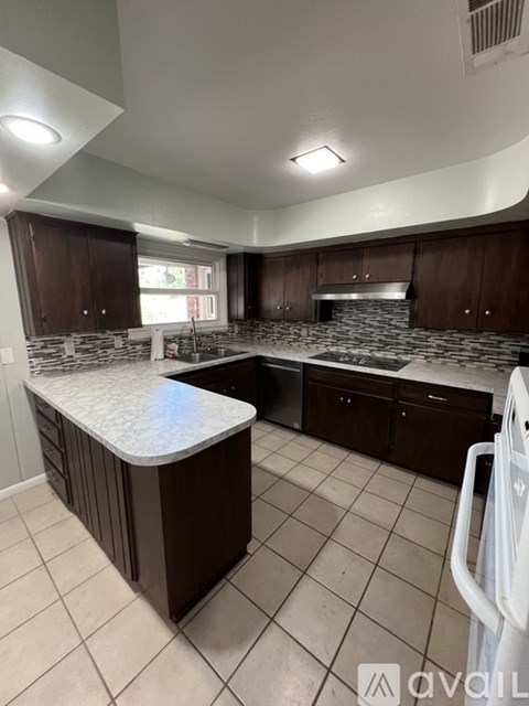 A kitchen with a white counter top and brown cabinets.