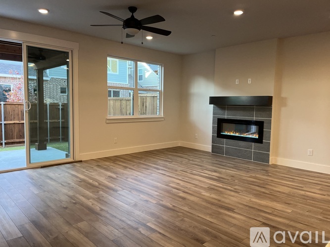 A spacious room with a fireplace and a ceiling fan.