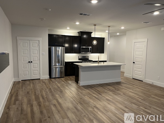 A kitchen with a white countertop and black cabinets.