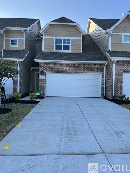 A house with a garage and a driveway in front.