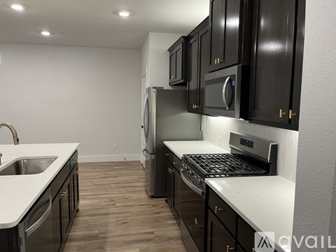 A kitchen with black cabinets and a white countertop.
