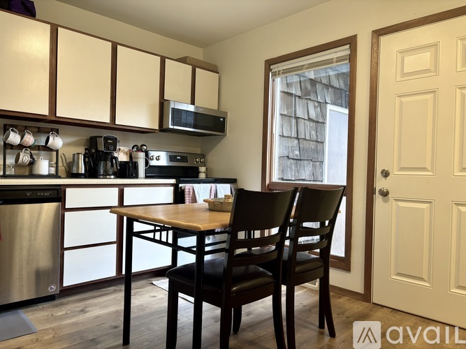 A kitchen with a table and chairs in front of a window.