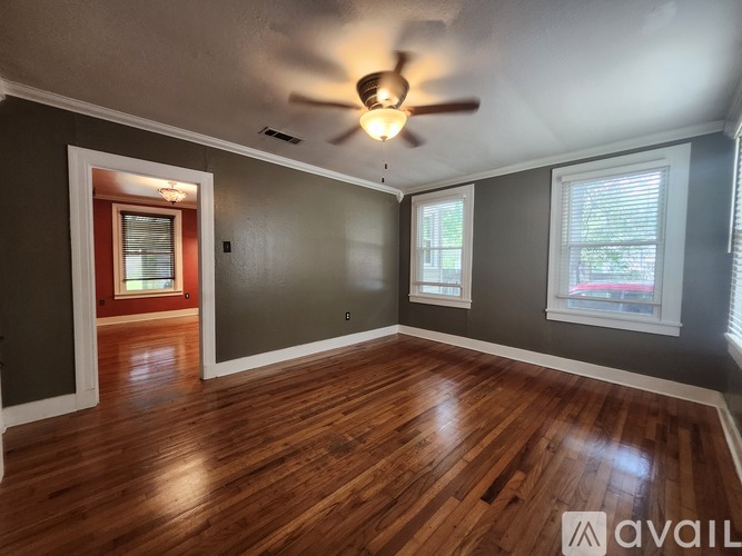 A room with wooden floors and a ceiling fan.