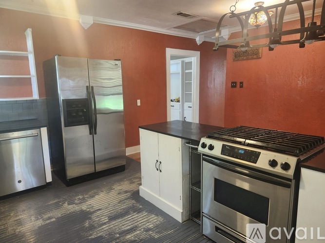 A kitchen with a stove top oven and a refrigerator.