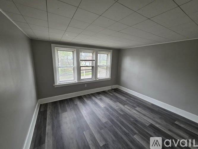 A room with a window and wooden flooring.