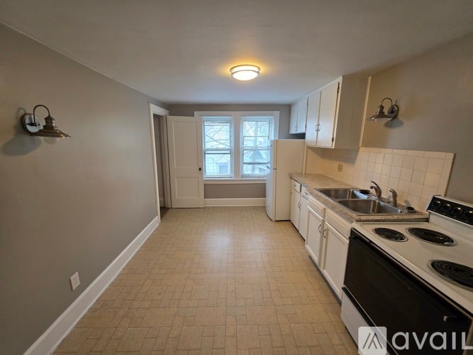 A kitchen with a black stove top oven and a window with a view of a tree.