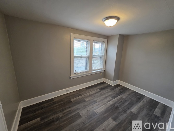 A room with a window and wooden flooring.