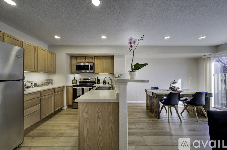 A kitchen with wooden cabinets and a stainless steel refrigerator.