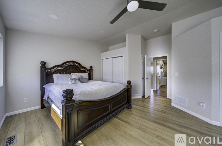 A bedroom with a large bed and wooden floors.