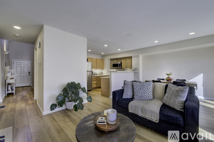 A living room with a dark blue couch and a coffee table in the middle.