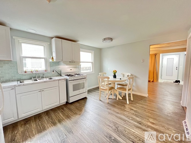 A kitchen with white cabinets and a wooden table.