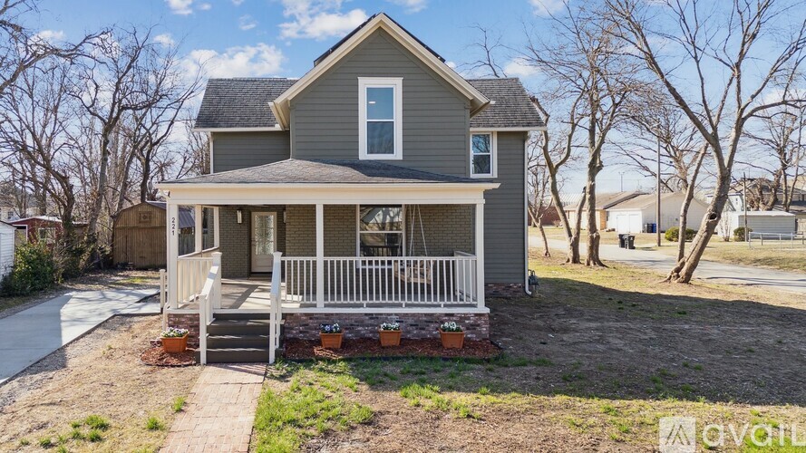 A house with a grey roof and white fence.