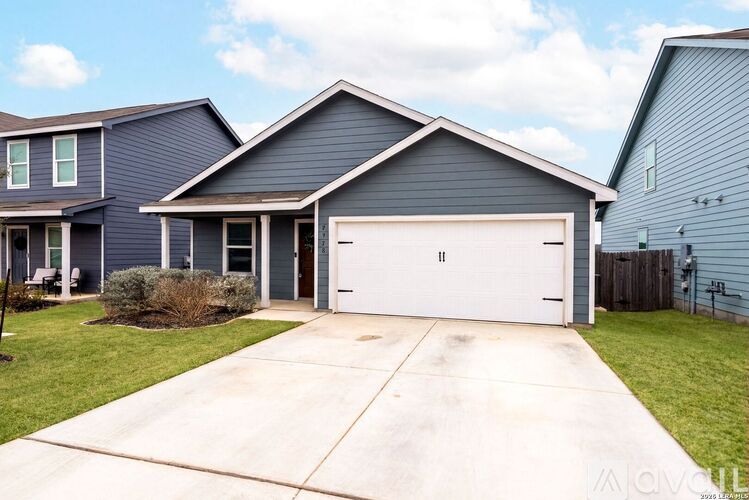 A two-story house with a garage and a driveway.