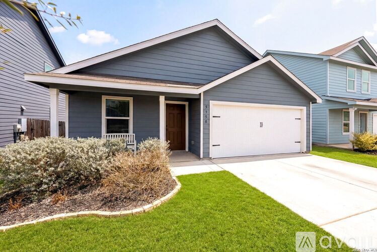 A house with a grey roof and a white garage door.