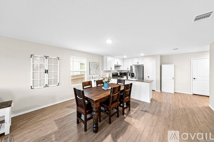 A kitchen with a dining table and chairs in the middle of the room.