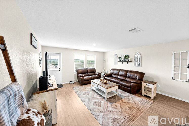 A living room with brown leather couches and a wooden floor.