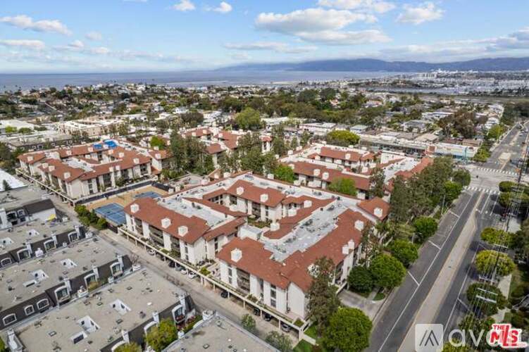 A bird's eye view of a residential area with apartment buildings and a road.