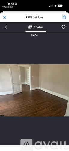 A room with wooden flooring and white walls.