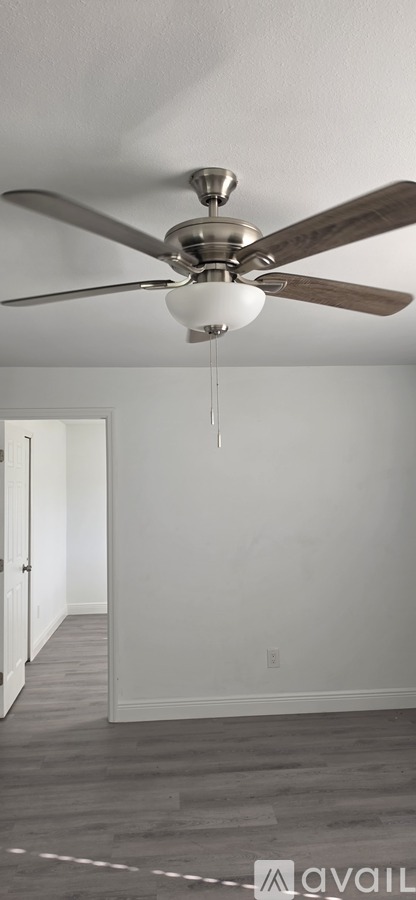 A ceiling fan with a light hanging from the center.