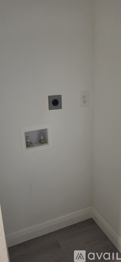 A wall with a square hole and a switch.