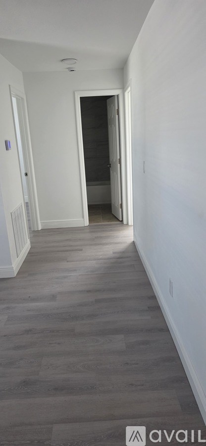 A hallway with a door at the end.