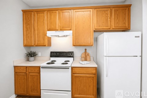 A kitchen with wooden cabinets and a white stove top oven.