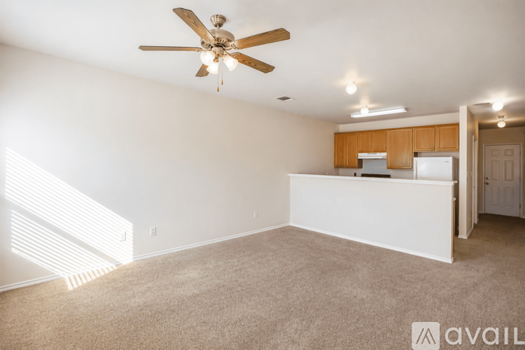 A spacious room with a ceiling fan and carpeted floor.