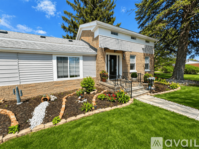 A house with a well-maintained lawn and landscaping is for sale.