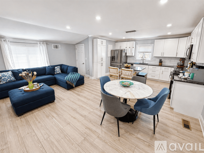 A modern kitchen and living room with a dining table and chairs.