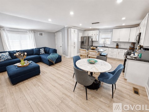 A modern kitchen and living room with a dining table and chairs.