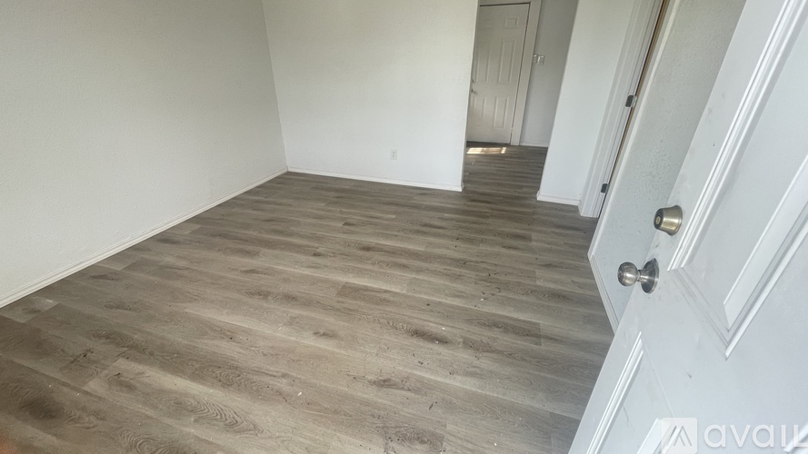 A room with a wooden floor and a white door.