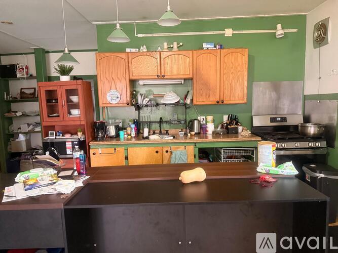 A kitchen with green walls and wooden cabinets.