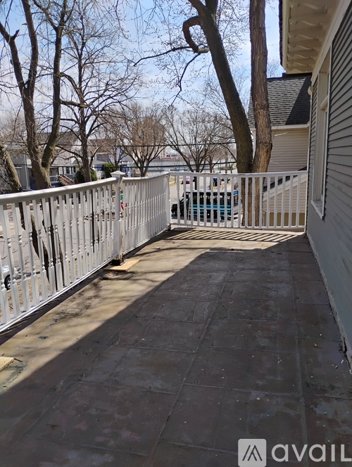 A long white fence runs along the side of a building.