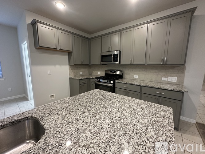 A kitchen with granite countertops and stainless steel appliances.