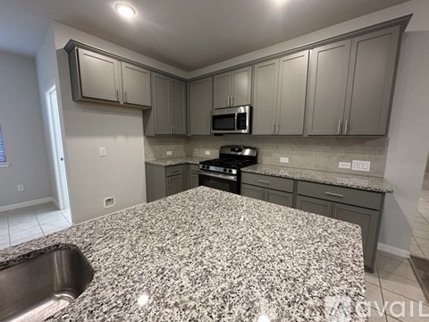 A kitchen with granite countertops and stainless steel appliances.