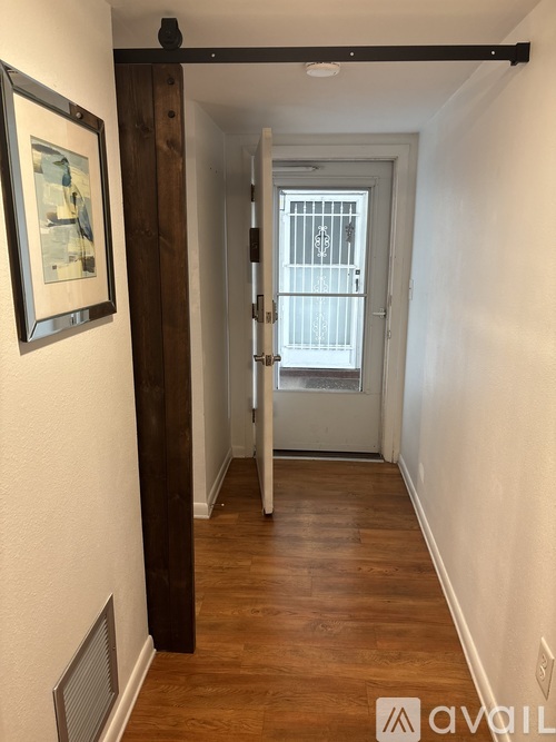 A hallway with a white door and a painting on the wall.