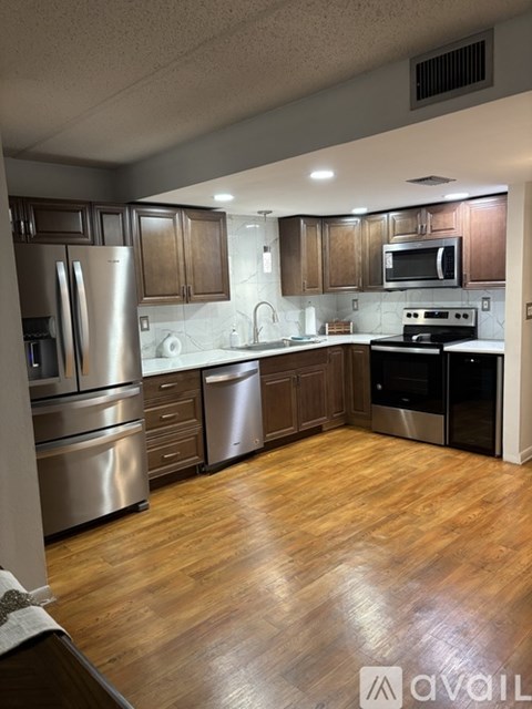 A kitchen with wooden cabinets and stainless steel appliances.